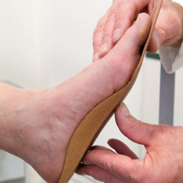 Doctor preparing orthopedic insoles for a patient on his studio